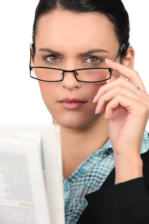 Woman in glasses reading a newspaperの写真素材