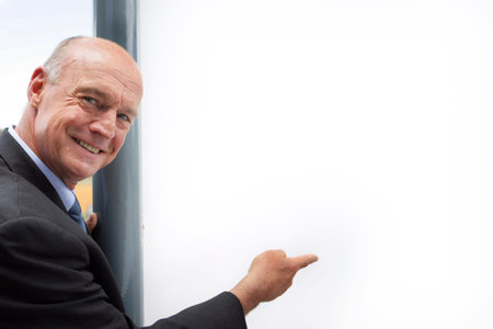 Senior businessman pointing at copyspace