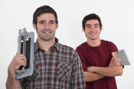 A team of tile fitters holding toolsの写真素材