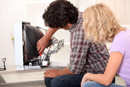 Husband repairing television setの写真素材