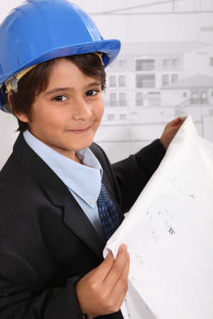 Boy with helmet and blueprintsの写真素材