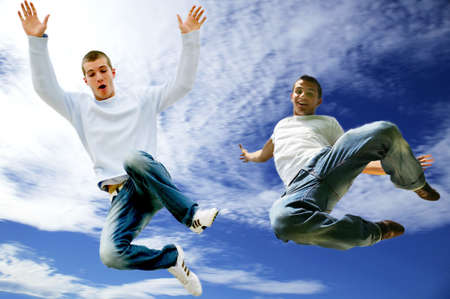 Two young men jumping in the airの写真素材