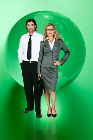 Businesspeople in front of green world mapの写真素材