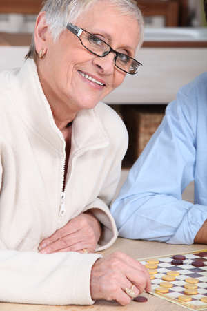 portrait of an old woman playing checkersの写真素材