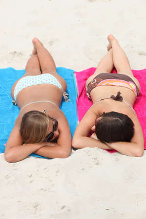 Girls sunbathing on the beachの写真素材