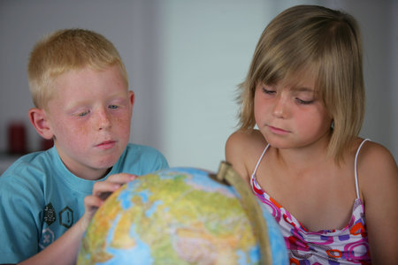 little boy and girl looking at a globeの写真素材