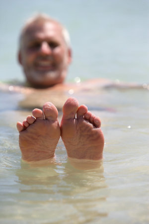 Man poking his feet out of the water