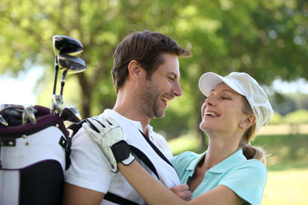 Couple embracing on the golf courseの写真素材