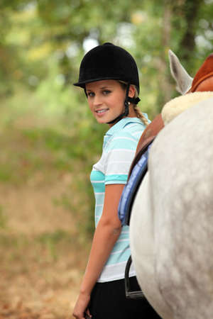 Woman standing next to her horseの写真素材