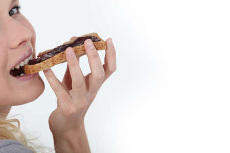 Woman eating jam on toastの写真素材