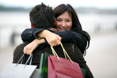 Woman thanking man for presents with hugの写真素材