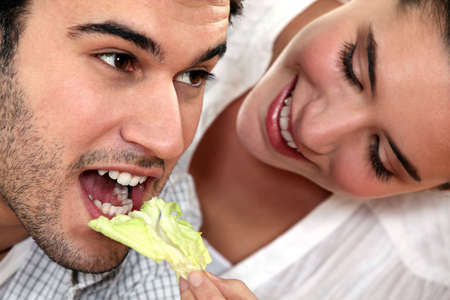 woman giving her boyfriend a saladの写真素材