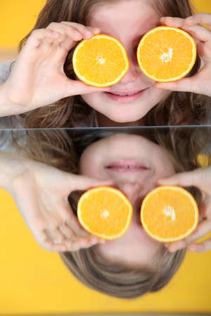 little girl playing with an orangeの写真素材