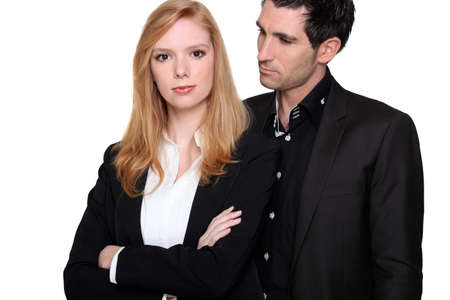 a business woman with crossed-arms and her colleagueの写真素材