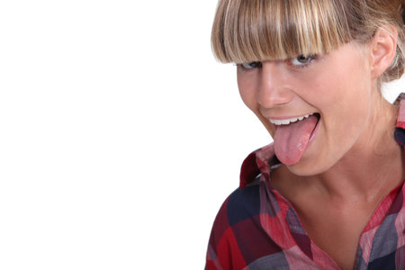 A blond teenager pulling her tongue out.