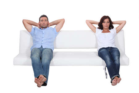 Couple sitting on white sofaの写真素材