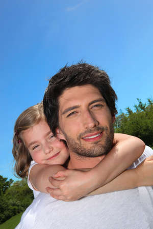 Dad giving his daughter a piggy backの写真素材
