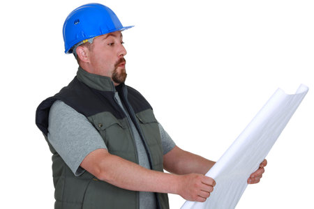 Surprised tradesman looking at a blueprint