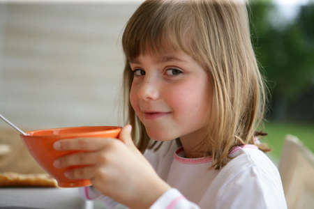 Little girl having breakfastの写真素材