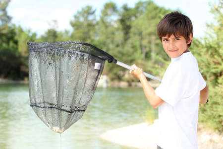 Young boy with a large fishing netの写真素材