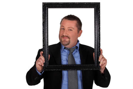 Businessman carrying frame in front of his faceの写真素材
