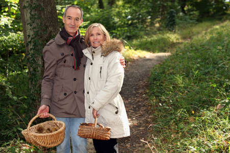 Couple with basket of chestnuts and mushroomsの写真素材