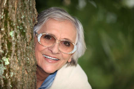 Woman against tree trunkの写真素材
