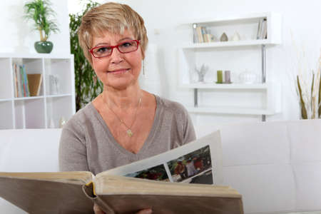 Woman looking at a photo albumの写真素材