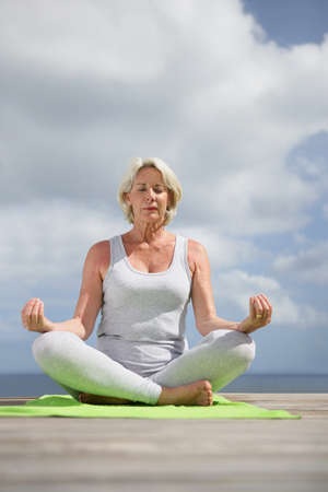 mature woman meditatingの写真素材