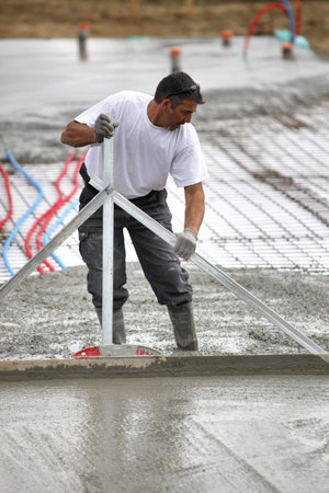 Man spreading wet cement