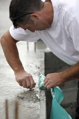 Mason removing plastic sheet from wallの写真素材