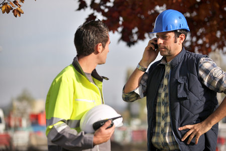 Construction workers on site with a phoneの写真素材