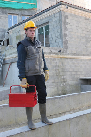 Construction worker on site with a toolbox