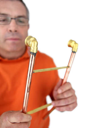 Plumber holding copper pipesの写真素材