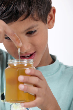 Little boy holding jar of honey
