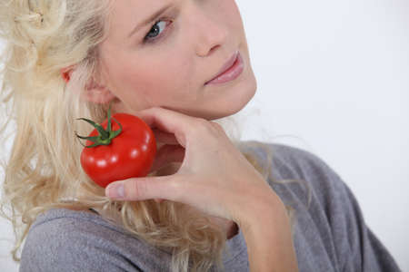 Blond woman holding tomatoの写真素材