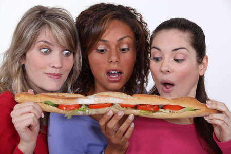 Friends eating a long sandwichの写真素材