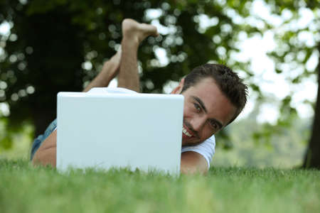Man using his laptop on a lawnの写真素材