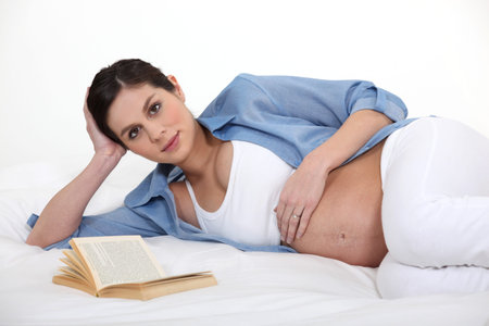 Pregnant woman reading to pass the time