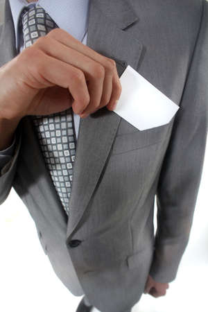 Businessman pulling a business card out of his pocketの写真素材