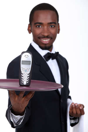 Waiter with a cellphone on a trayの写真素材