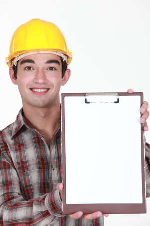 Young construction worker holding up a blank clipboardの写真素材