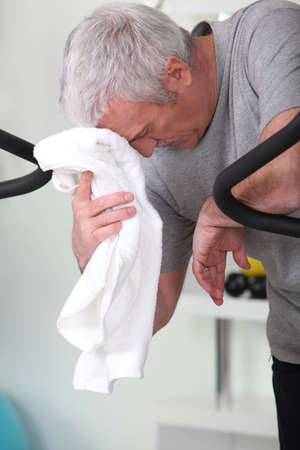 Exhausted man stood in gymの写真素材