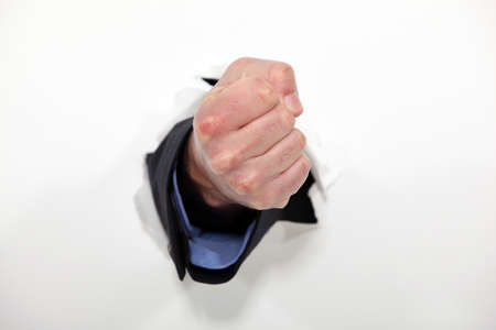 Fist emerging from wallの写真素材