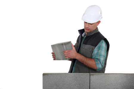 Man placing brick on unfinished wall