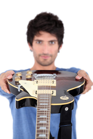 Man holding an electric guitar at arms length
