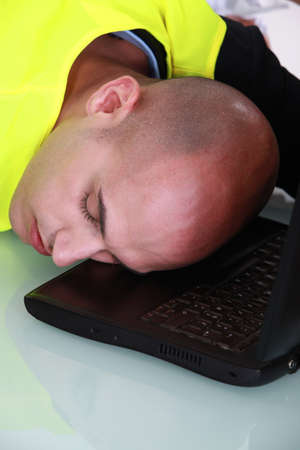 Man fast asleep at his deskの写真素材