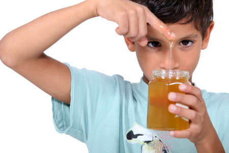 Boy playing with honeyの写真素材