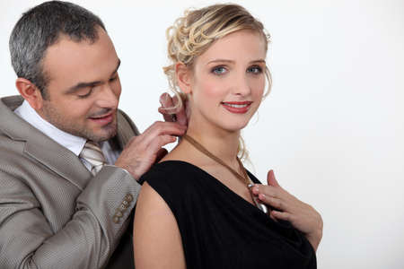 man offering his girlfriend a necklaceの写真素材