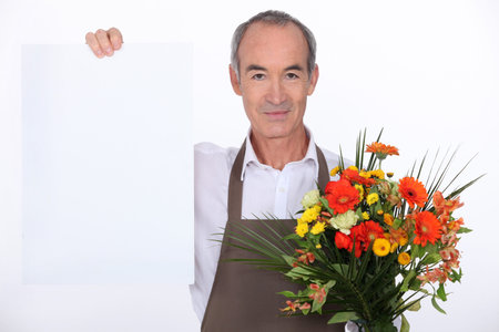 Male florist holding message boardの写真素材